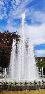 Water splashing fountain against sky