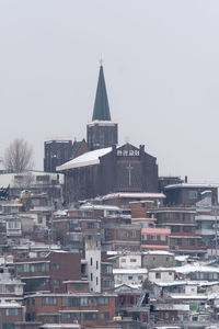 Snowy church and neighborhood in seoul. the snow cover the roofs on a gray day of winter.