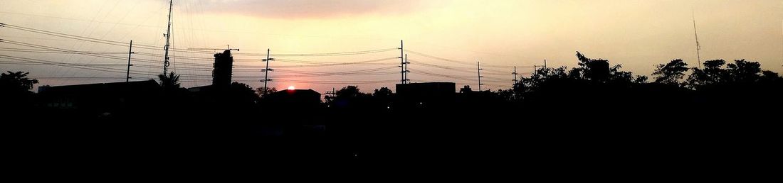 Silhouette of electricity pylon at sunset