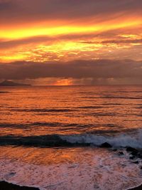 Scenic view of sea against dramatic sky during sunset