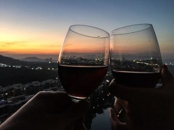 Wineglasses against sky during sunset