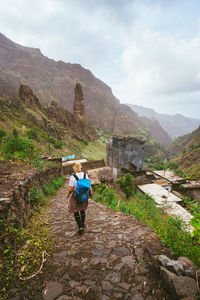 Rear view of woman walking on staircase against sky