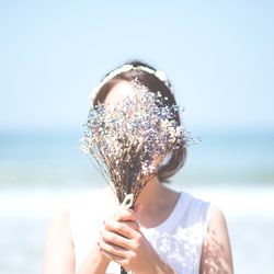 Bride obscuring face with bouquet