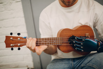 Midsection of man playing guitar