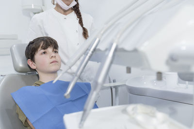 Boy lying on dentist chair