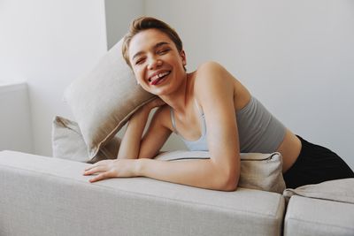 Young woman sitting on sofa at home