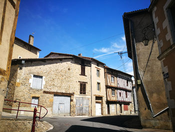 Low angle view of old buildings against blue sky