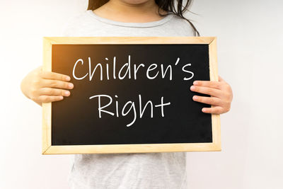 Midsection of woman holding text against white background