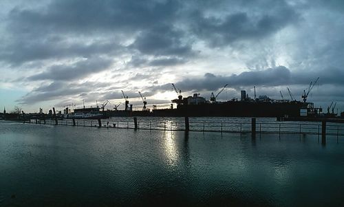 Commercial dock against cloudy sky