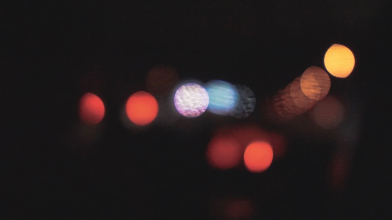 DEFOCUSED IMAGE OF ILLUMINATED LIGHTS ON STREET