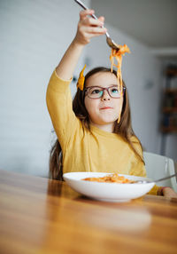 Portrait of teenage girl eating food at home