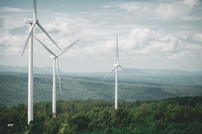 Windmills on landscape against sky