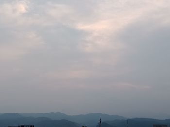 Man standing on mountain against sky during sunset