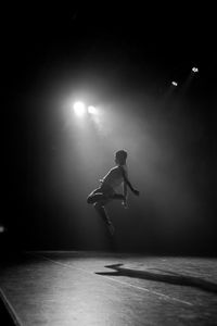 Rear view of man jumping on stage