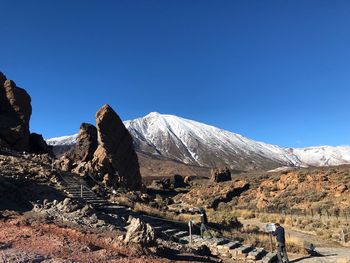 Scenic view of snowcapped mountains against clear blue sky