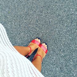 Low section of woman standing on road