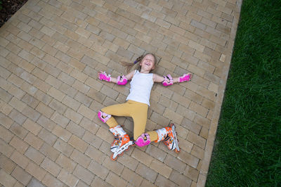 High angle view of woman sitting on footpath