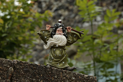 Low angle view of figurine against trees