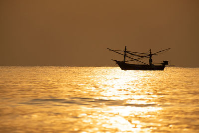 Silhouette boat in sea against sky during sunset