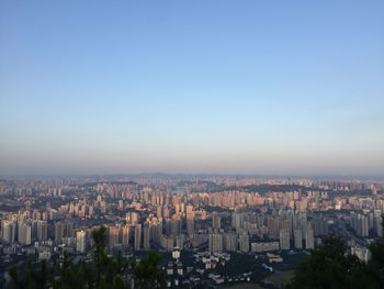 High angle view of buildings in city against clear blue sky