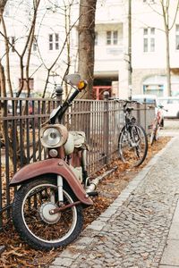 Bicycle parked by tree in city