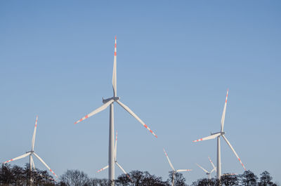 Low angle view of windmill against clear blue sky