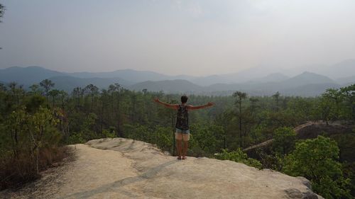 Rear view of woman standing on mountain landscape