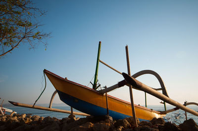 Low angle view of abandoned boat against clear blue sky