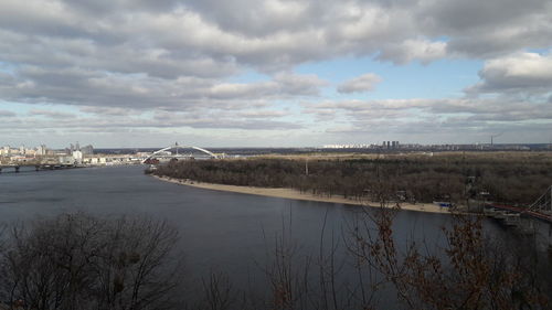 Bridge over river in city against sky