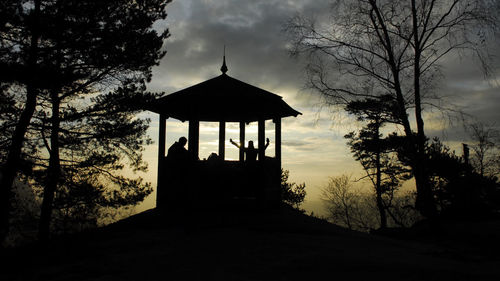 Silhouette of trees against cloudy sky