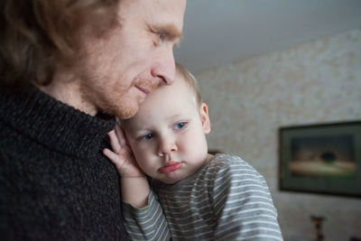 Mature man with grandson in living room at home