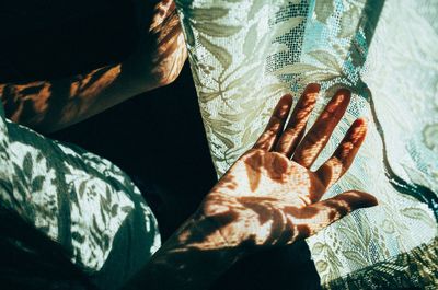 High angle view of person palm by curtain with sunlight