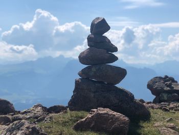 Stack of stones on rock against sky