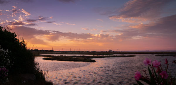 Scenic view of river against sky during sunset
