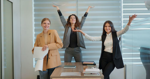 Three business woman celebrating success dancing at workplace. 
