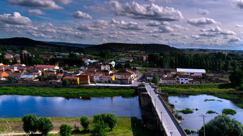 Houses by lake against sky