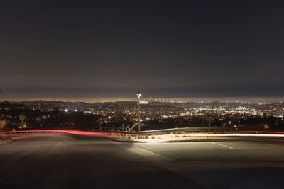 Illuminated city against sky at night