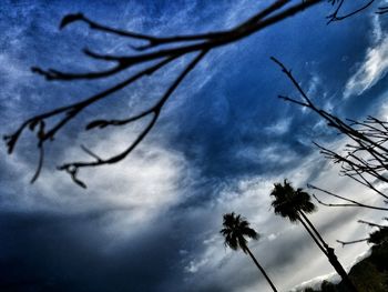 Low angle view of bare tree against cloudy sky