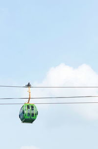 Low angle view of overhead cable cars against sky