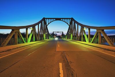 Surface level of road against clear blue sky