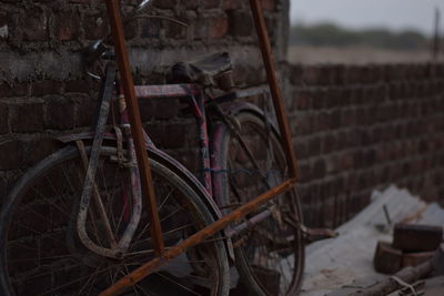 Abandoned bicycle against wall