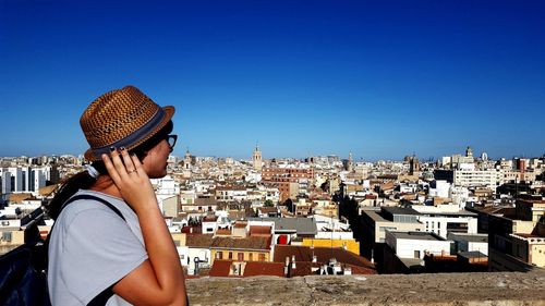 Midsection of woman against clear blue sky