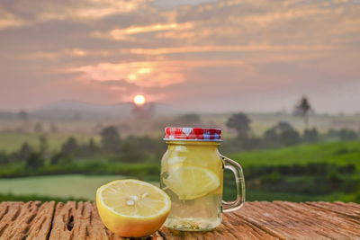 Drink on table against orange sky