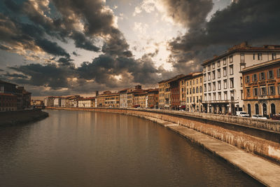 Canal amidst buildings in city against sky