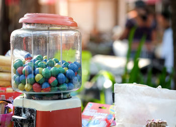 Close-up of multi colored candies in glass jar on table