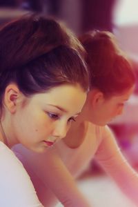 Close-up of teenage ballerina by mirror at dance studio