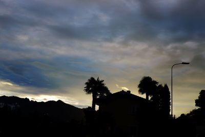 Silhouette houses against sky during sunset