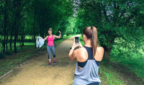 Woman running on street amidst trees in forest