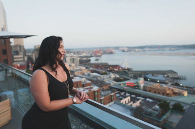 Young woman standing at building terrace in city