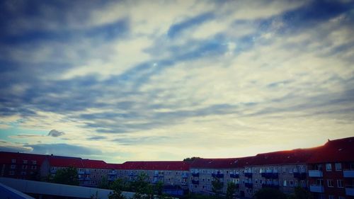 Buildings in town against cloudy sky